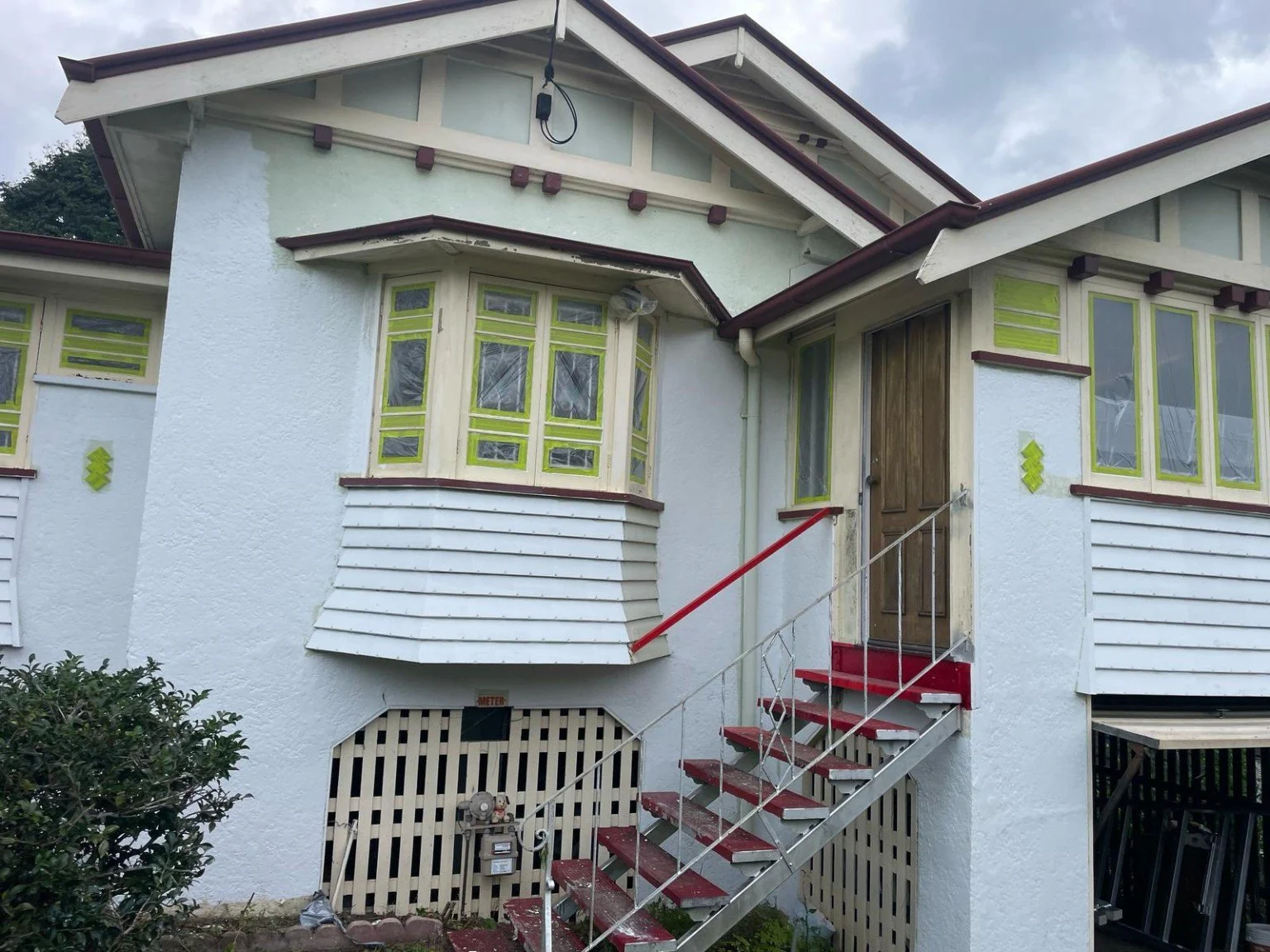 Windows and stairs masked on a weatherboard home
