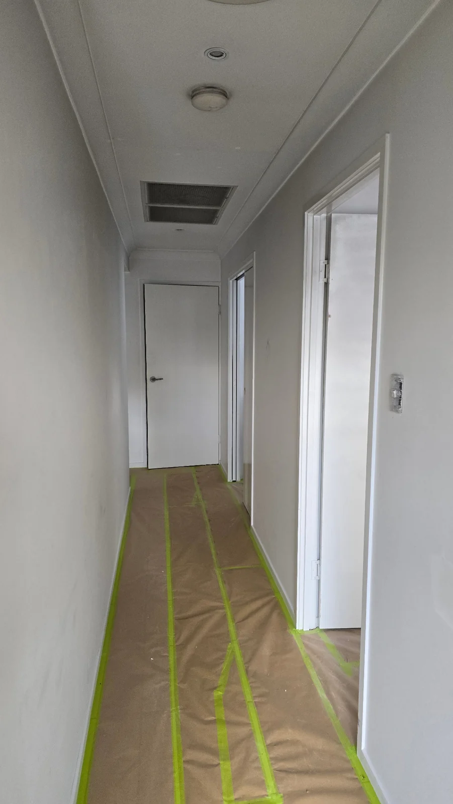 Hallway floor protected with paper and green masking tape